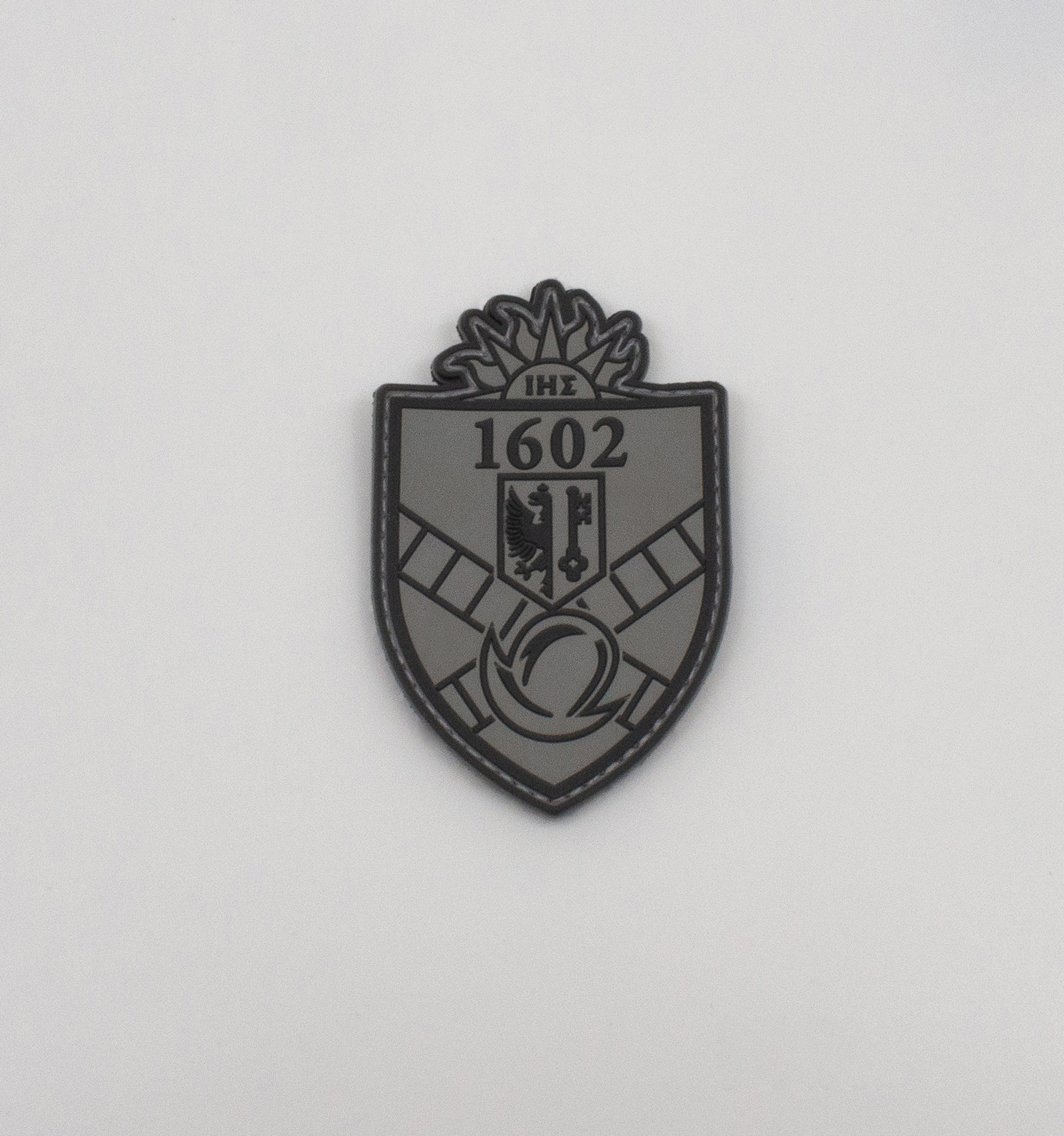 Patch blason 1602 gris en PVC, robuste et détaillé. Idéal pour vêtements, sacs ou équipements. Qualité premium, livraison rapide en Suisse.