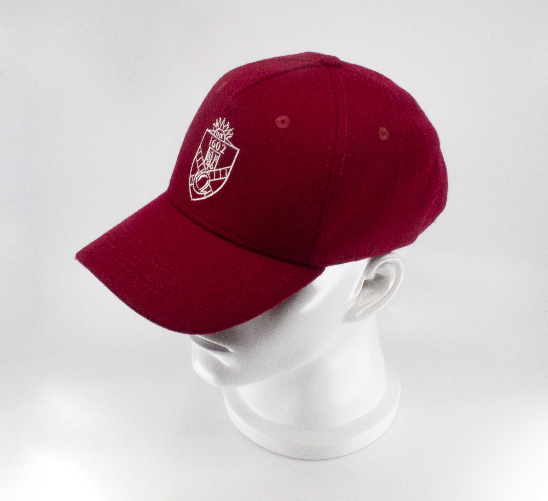 Casquette 1602 en laine rouge/grenat avec blason brodé blanc. Élégante, sobre et inspirée de la tradition genevoise. Livraison rapide en Suisse.